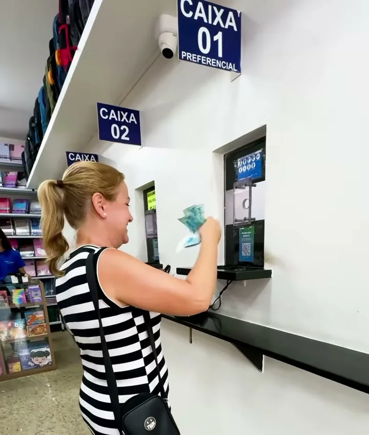 Cliente no caixa 2 da loja, com a placa Caixa 1 preferencial acima